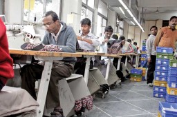 Perforated box shaped work aids below the stool of operators on shopfloor