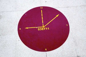 A permanent mark on the floor with team numbers that signify when they are to have their daily Level-1 meeting to discuss issues – each team has a clock specifically marked to them