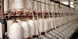 Spools of thread on machinery in textile mill