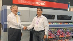 Akiyoshi Ohno, President, Konica Minolta with Vir Vikram Bhatia, MD, Apsom Technologies, pose in front of the Nassenger PRO 60 printer