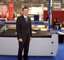 Claudio Roberto Grando in front of the new Neocut cutting machine of Audaces. The Audaces Tower Jet vertical plotter (right) was one of the nominees for IMB Innovation Award