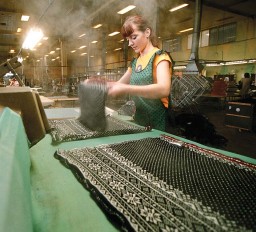 A woman working with a steam-iron machine at the knitwear enterprise “Ogre” in Ogre, Latvia