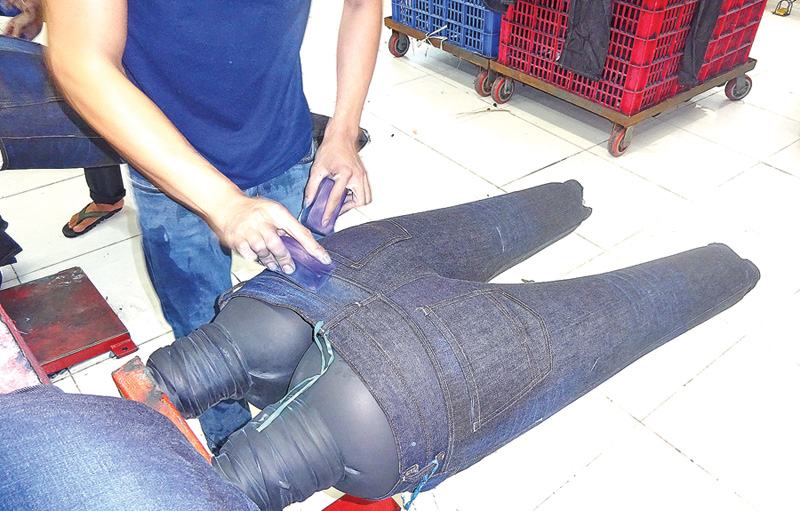 Denim being abraded with sandpaper